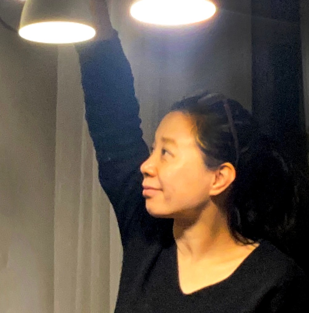 Fan Xiang reaching toward a hanging light