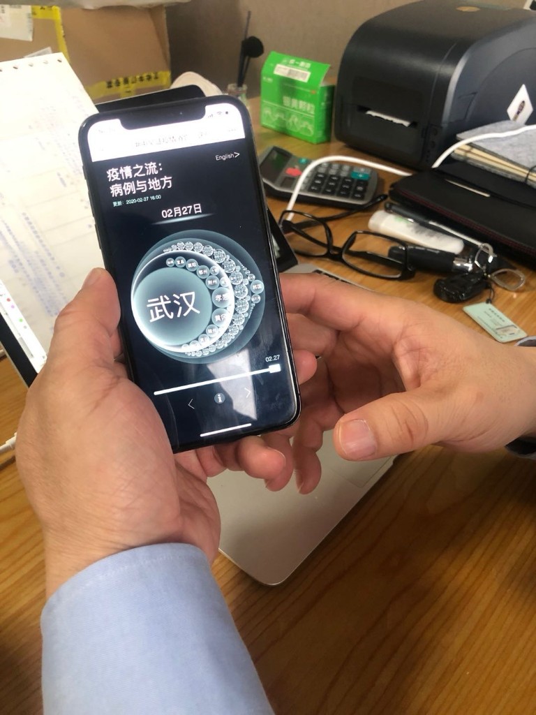 Hands holding a phone showing CaseFlow Circle Packing at a desk