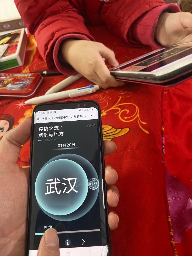 A phone showing CaseFlow beside a child at home during quarantine
